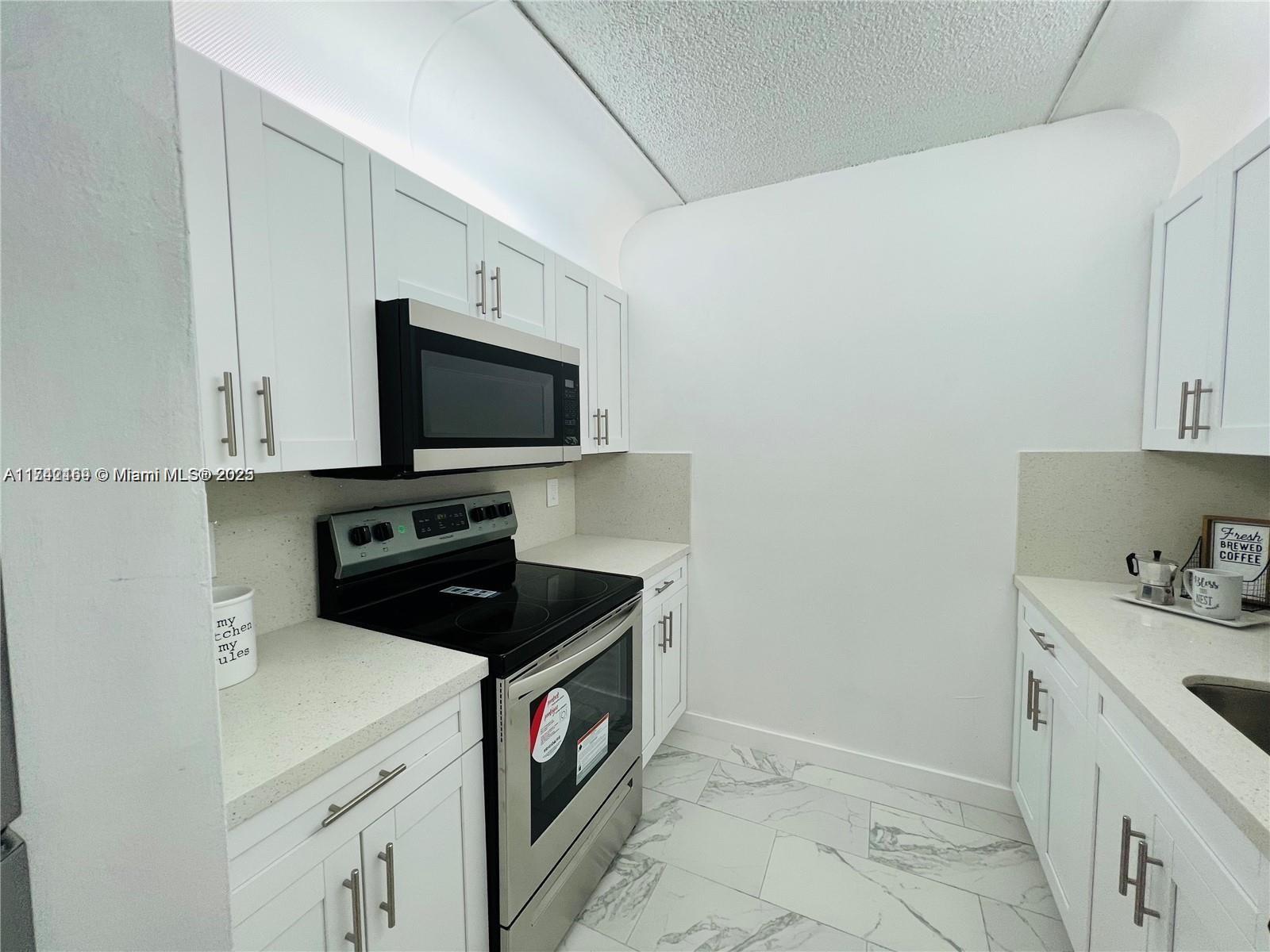 8260 Southwest 210th Street, Unit 220 Cutler Bay, FL 33189 - Photo 2 of 20 a kitchen with a sink and a stove top oven