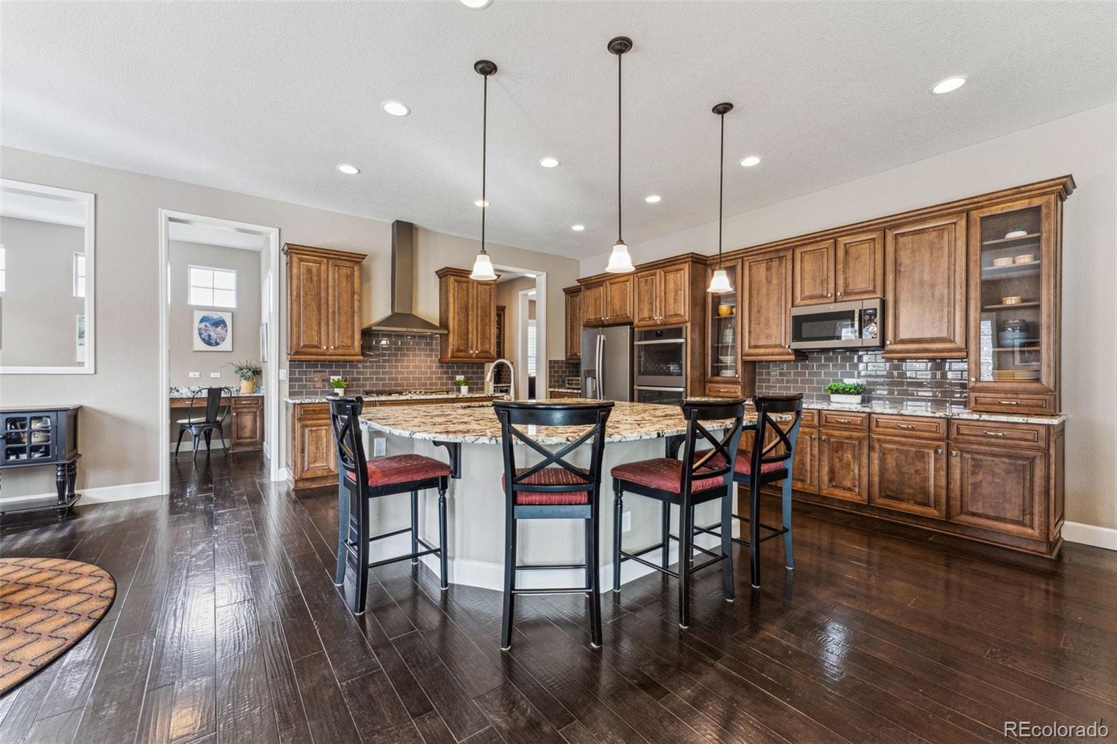 4937 Hogback Ridge Road Morrison, CO 80465 - Photo 12 of 43 a kitchen with stainless steel appliances kitchen island granite countertop furniture wooden floor and a view of living room