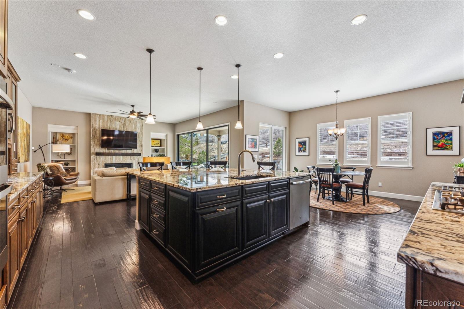 4937 Hogback Ridge Road Morrison, CO 80465 - Photo 14 of 43 a kitchen with stainless steel appliances granite countertop wooden floors and a view of living room