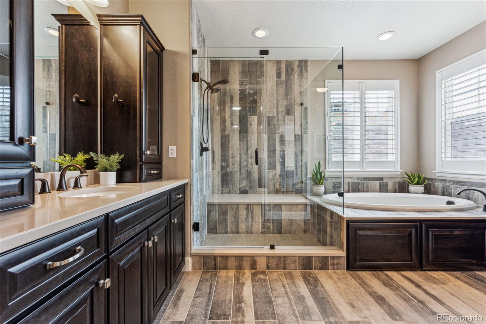 4937 Hogback Ridge Road Morrison, CO 80465 - Photo 23 of 43 a spacious bathroom with a double vanity sink a large mirror and a bathtub