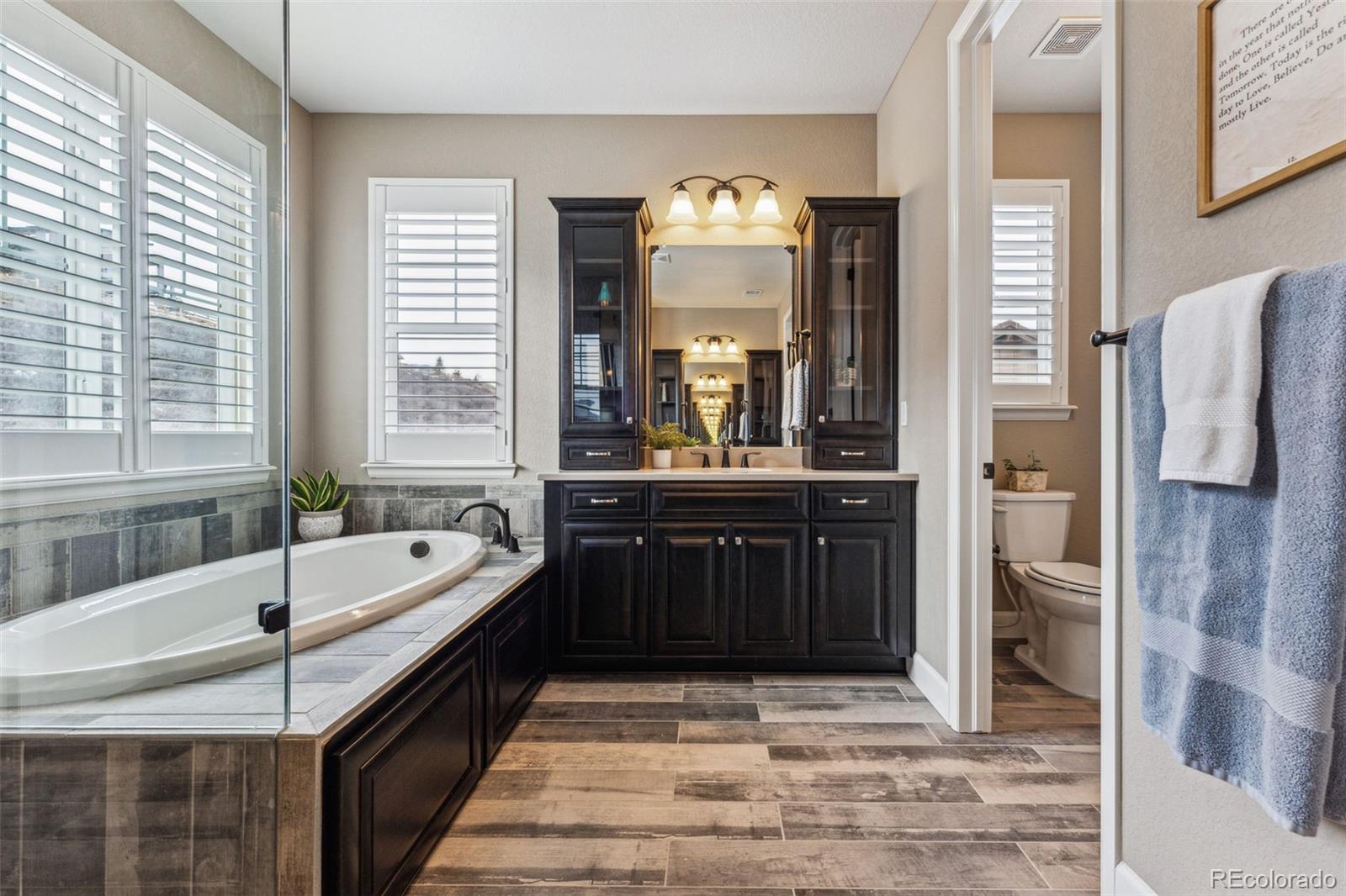 4937 Hogback Ridge Road Morrison, CO 80465 - Photo 24 of 43 a bathroom with a bathtub a sink and a large mirror