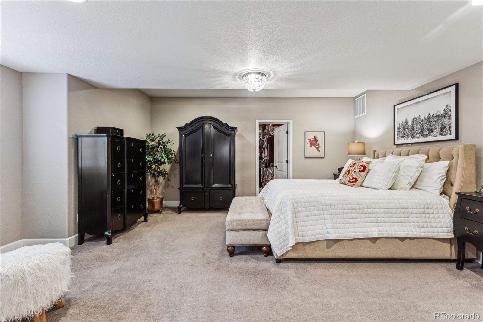 4937 Hogback Ridge Road Morrison, CO 80465 - Photo 38 of 43 a spacious bedroom with a bed and a refrigerator