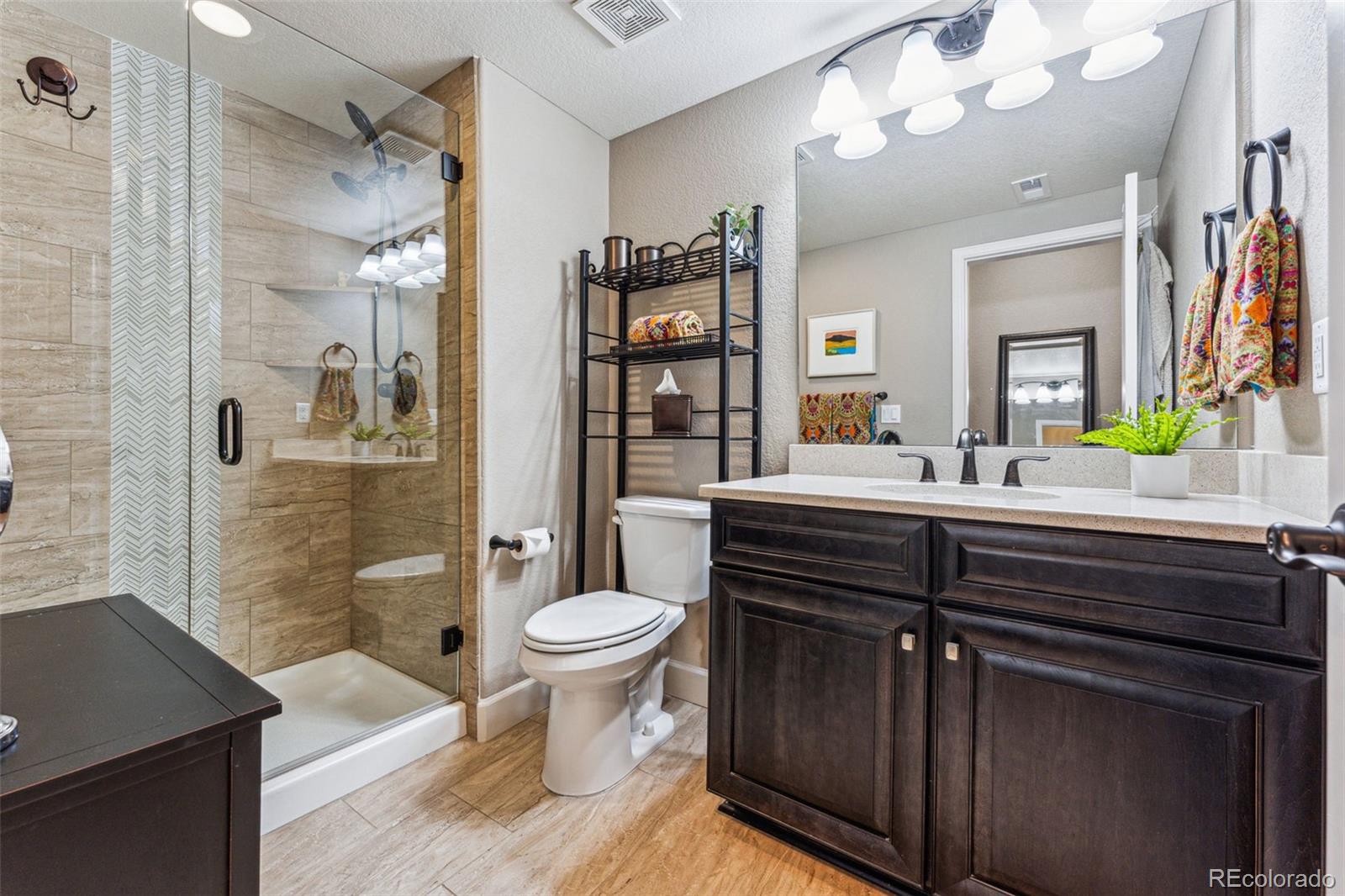 4937 Hogback Ridge Road Morrison, CO 80465 - Photo 39 of 43 a bathroom with a sink a toilet and shower