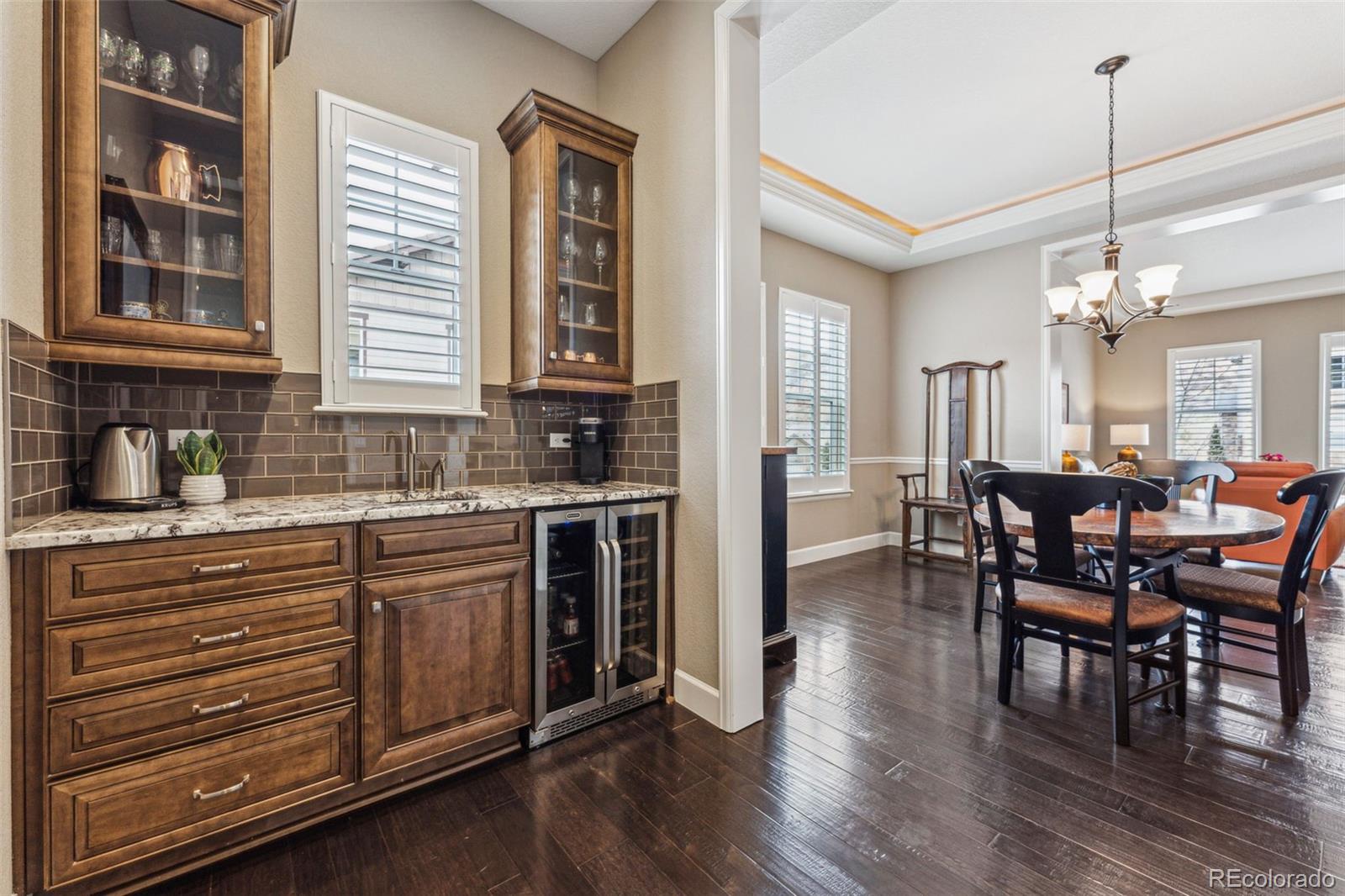 4937 Hogback Ridge Road Morrison, CO 80465 - Photo 6 of 43 a kitchen with stainless steel appliances granite countertop a stove top oven a sink dishwasher a dining table and chairs with wooden floor
