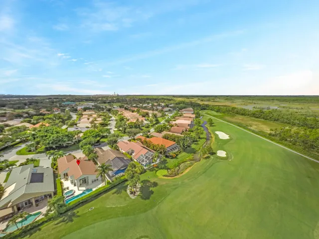 an aerial view of residential houses with outdoor space and trees