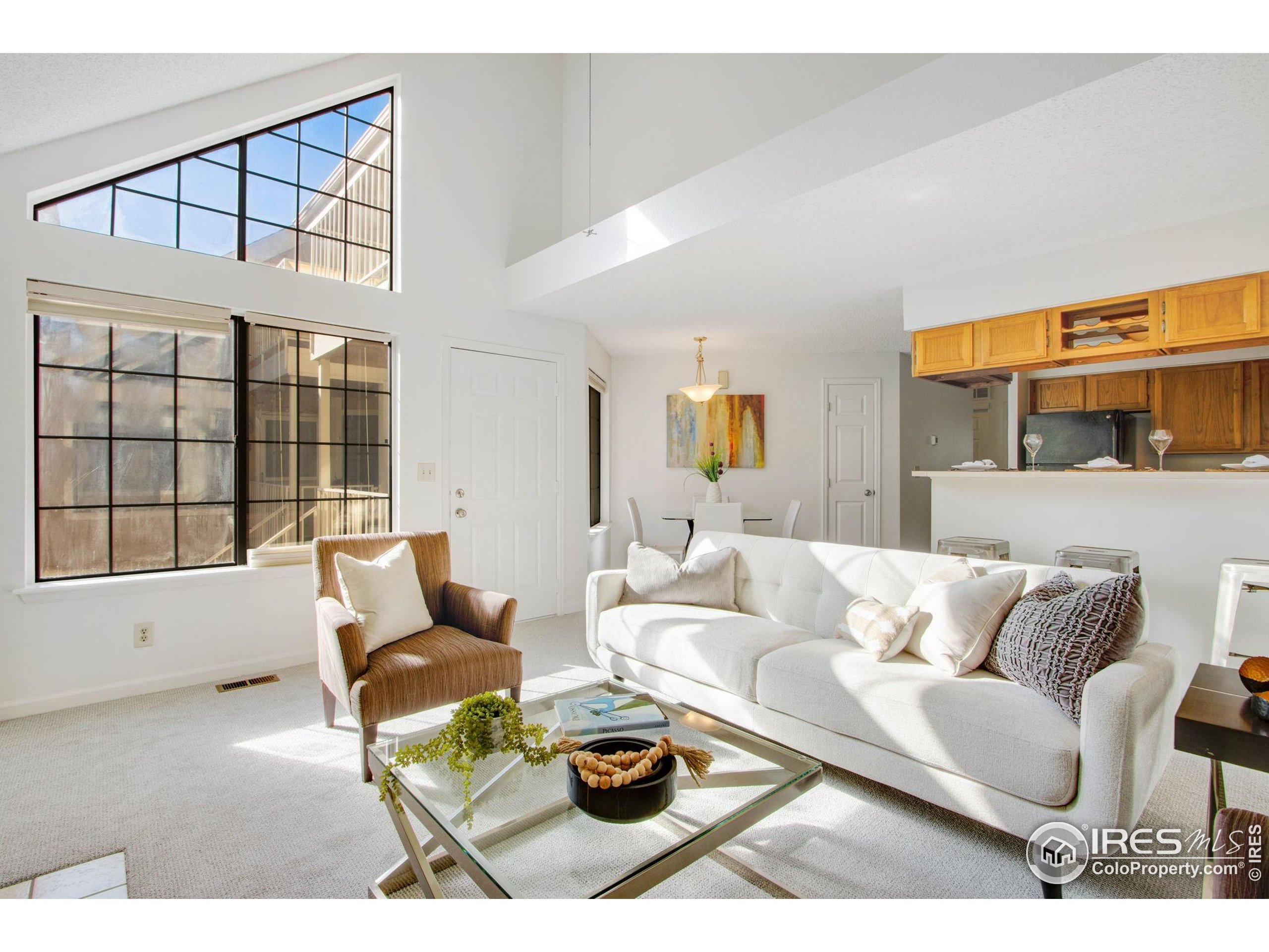 a living room with furniture a rug and a large window