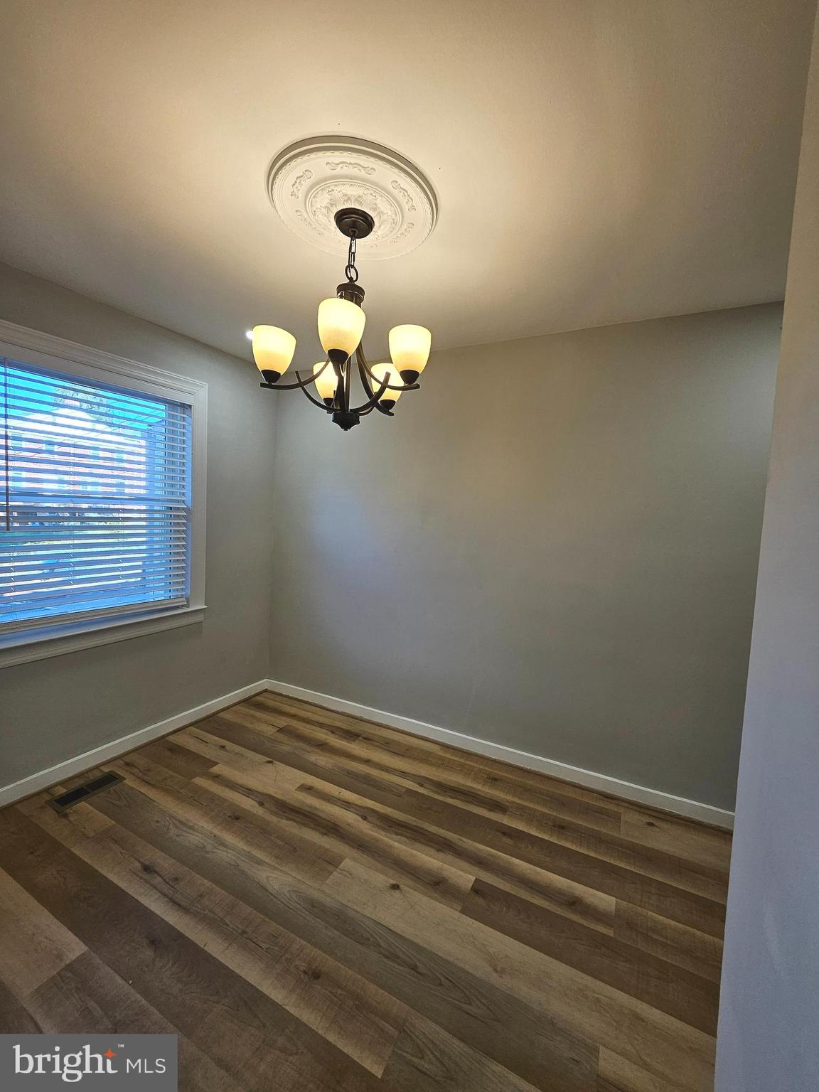 4546 Mountview Road Baltimore, MD 21229 - Photo 12 of 45 a view of a chandelier fan and wooden floor
