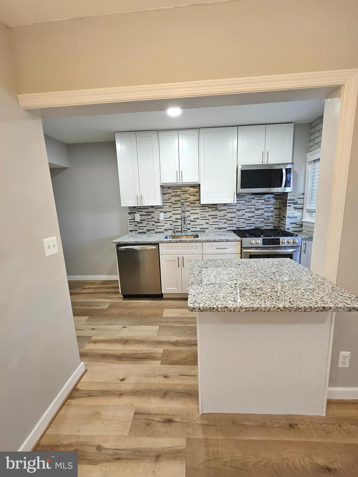 4546 Mountview Road Baltimore, MD 21229 - Photo 17 of 45 a kitchen with stainless steel appliances granite countertop a stove a sink and a microwave