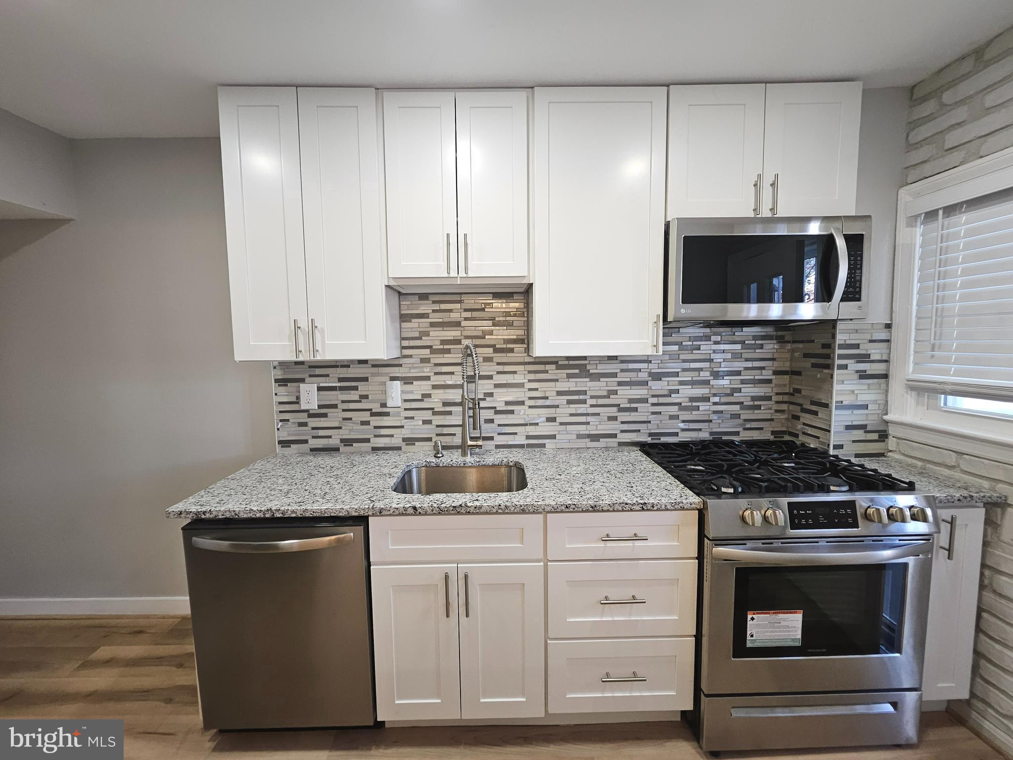4546 Mountview Road Baltimore, MD 21229 - Photo 18 of 45 a kitchen with stainless steel appliances granite countertop a stove and a microwave