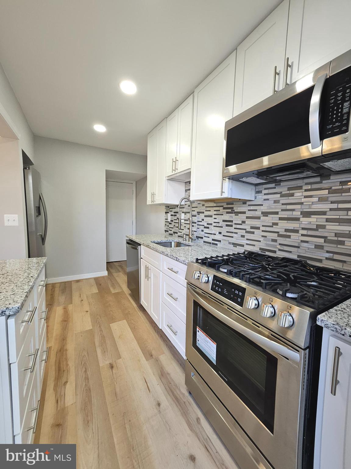 4546 Mountview Road Baltimore, MD 21229 - Photo 21 of 45 a kitchen with a stove and a microwave