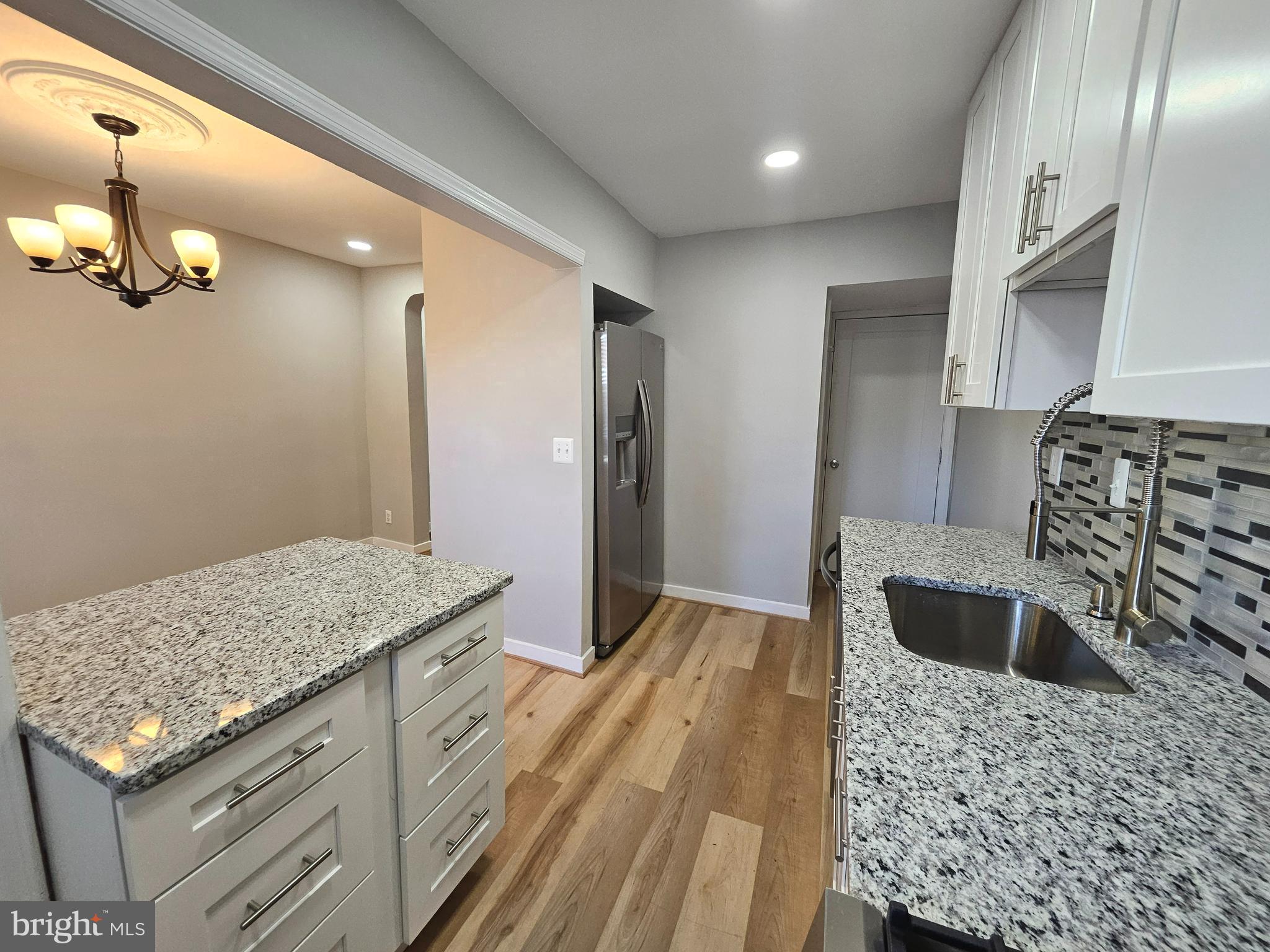 4546 Mountview Road Baltimore, MD 21229 - Photo 23 of 45 a kitchen with stainless steel appliances granite countertop a sink refrigerator and stove