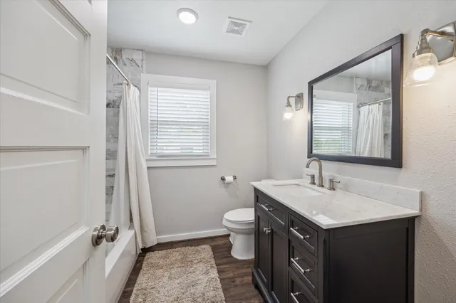 a bathroom with a sink a toilet and shower