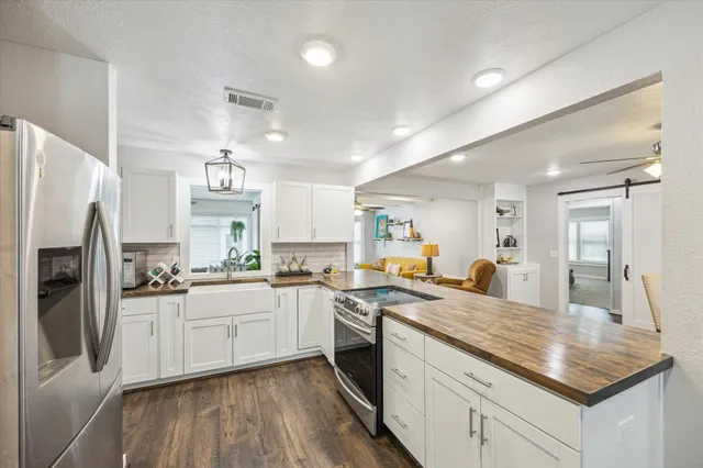 a kitchen with a sink a refrigerator and cabinets