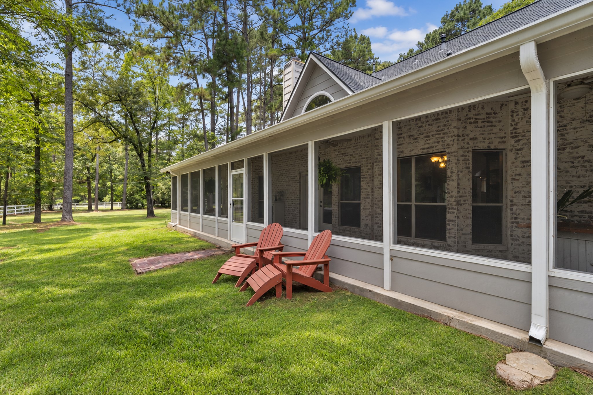 19610 Timber Ridge Drive Magnolia, TX 77355 - Photo 32 of 49 An outside view of the screened in patio shows just how it creates the perfect place to enjoy the outdoors in comfort, offering peaceful views of the surrounding trees and acreage.
