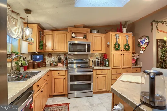 a kitchen with kitchen island a stove a sink and white cabinets