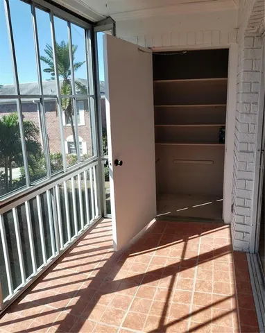 a view of a porch with wooden floor and a floor to ceiling window