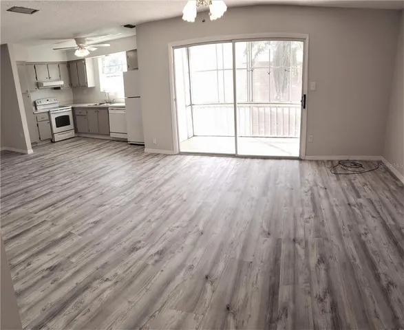 wooden floor in an empty room with a kitchen