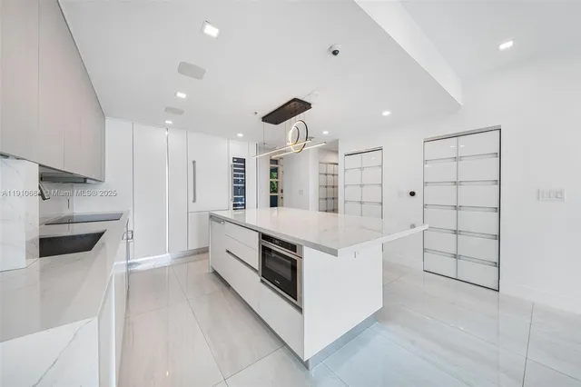 a large white kitchen with white cabinets and stainless steel appliances