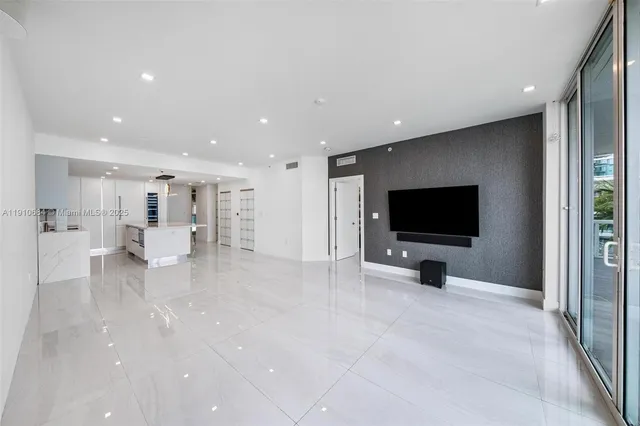 a view of a livingroom with wooden floor and a flat screen tv