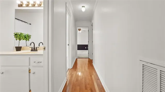 a view of a hallway with wooden floor and closet