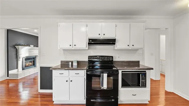 a kitchen with stainless steel appliances a stove a microwave and cabinets