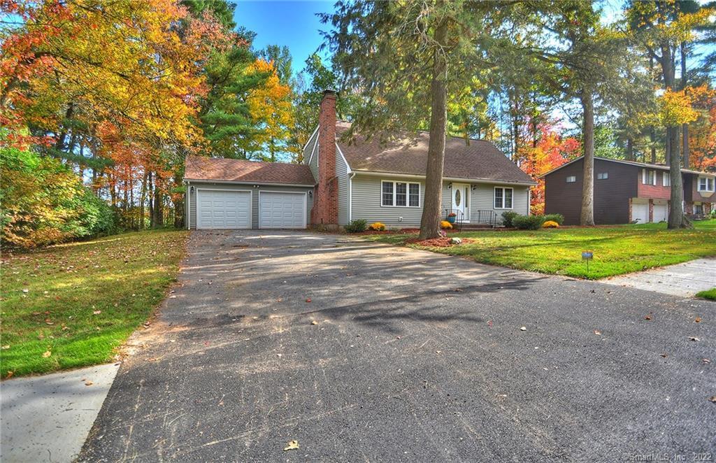 a front view of a house with a yard and trees