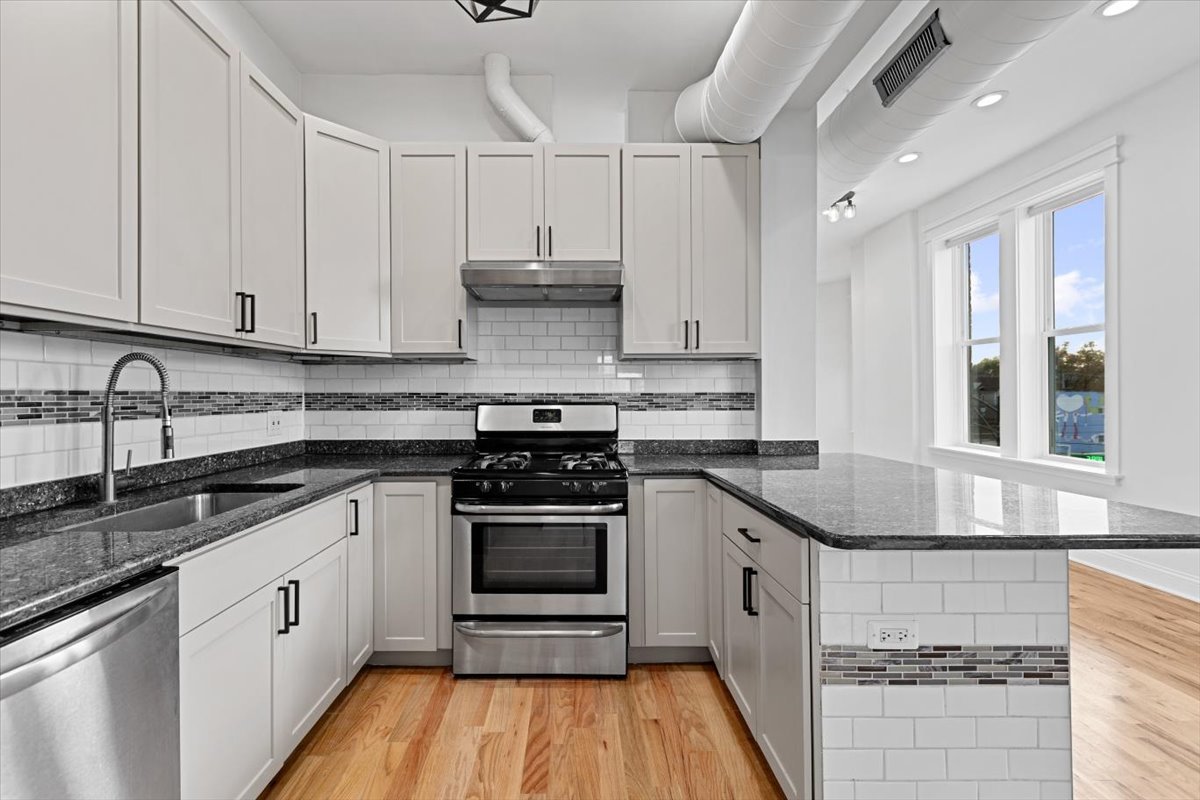 2346 West Fullerton Avenue, Unit 3 Chicago, IL 60647 - Photo 5 of 15 a kitchen with stainless steel appliances granite countertop a stove a sink and white cabinets