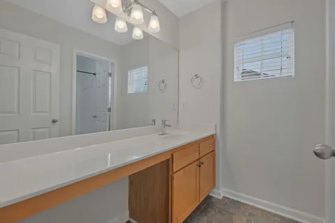 a bathroom with a sink a vanity and a large mirror
