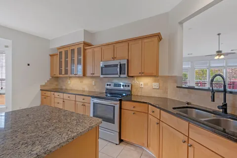 a kitchen with stainless steel appliances granite countertop a sink stove and cabinets