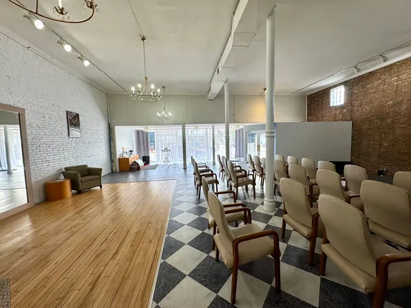 a room with a black white checkered floor with couches chair and a coffee table