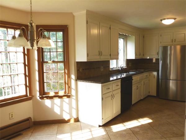 20 West Colonial Road Wilbraham, MA 01095 - Photo 5 of 18 a kitchen with granite countertop a refrigerator a sink a stove and white cabinets with wooden floor