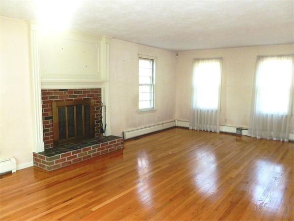 20 West Colonial Road Wilbraham, MA 01095 - Photo 9 of 18 an empty room with wooden floor fireplace and windows