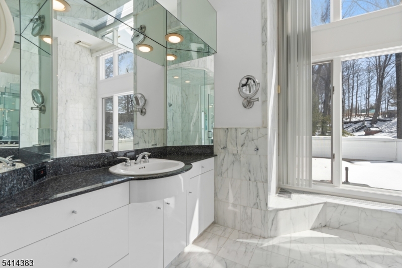2 Old Mill Road North Caldwell, NJ 07006 - Photo 14 of 25 a spacious bathroom with a granite countertop sink a mirror a shower and a bathtub