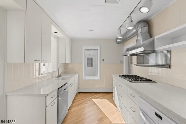 a kitchen with granite countertop a sink stove and cabinets
