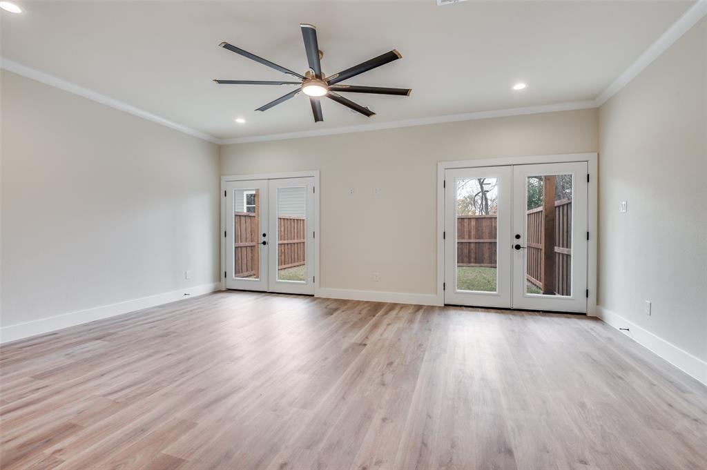420 Sparks Street Dallas, TX 75203 - Photo 3 of 12 a view of an empty room with wooden floor and a ceiling fan