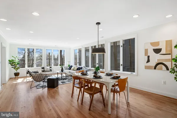 a view of a dining room and livingroom with furniture wooden floor a chandelier