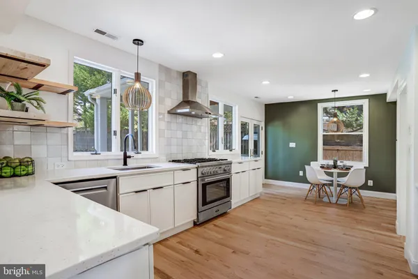 a kitchen with stainless steel appliances granite countertop a stove and a wooden floors