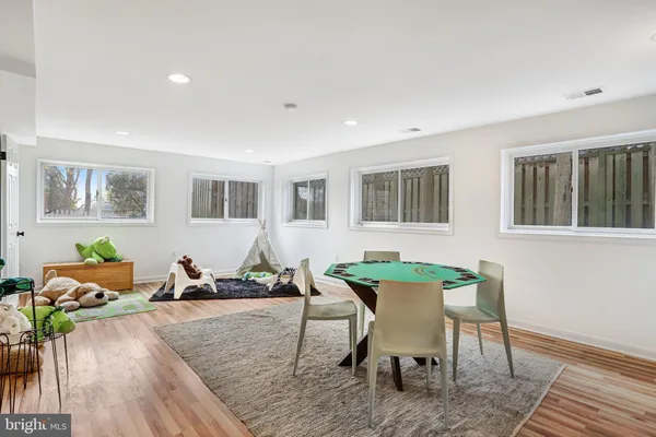 a living room with furniture a rug and wooden floor
