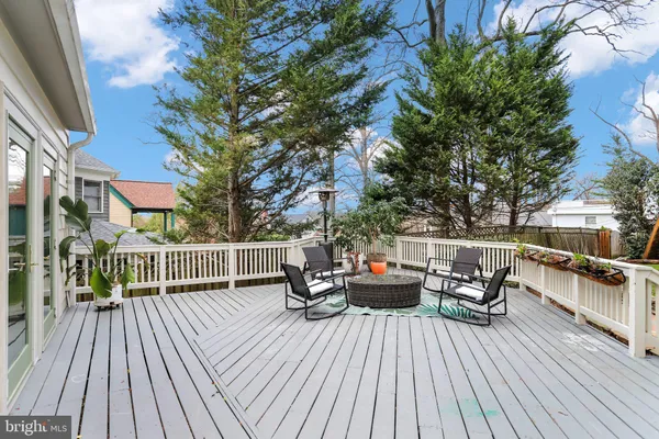 a view of a patio with dining table and chairs with wooden floor and fence