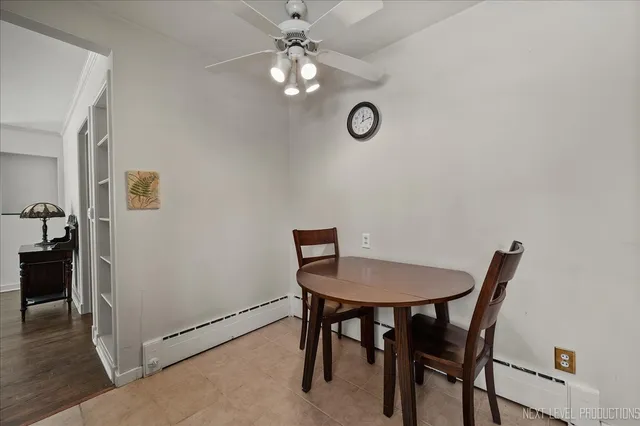 a view of a dining room with furniture and a chandelier fan