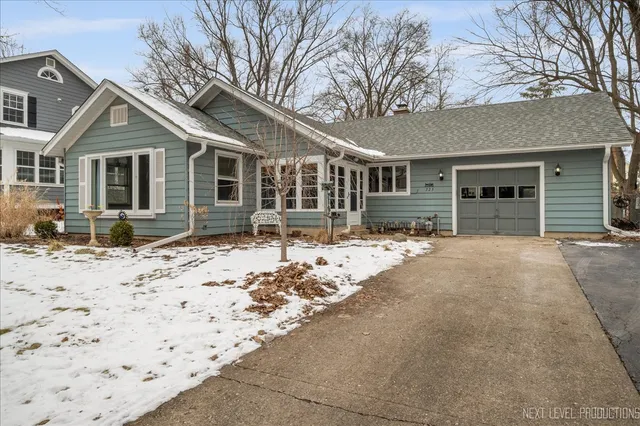 a front view of a house with a yard covered in snow