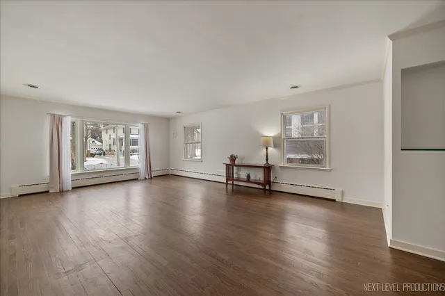an empty room with wooden floor and window