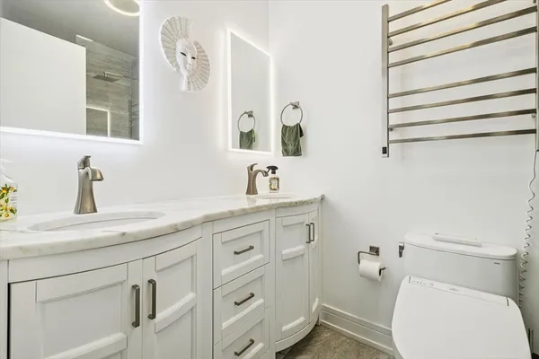a bathroom with a sink a toilet and mirror