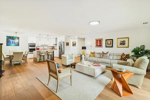 a living room with furniture and a dining table with kitchen view