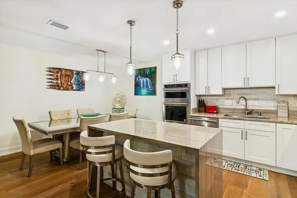 a kitchen with a dining table chairs and sink