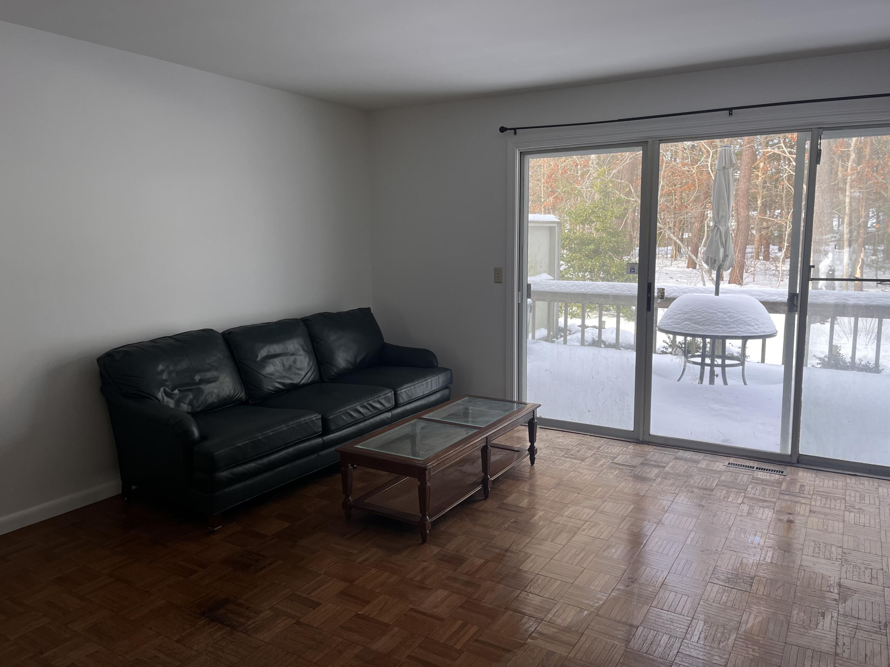 300 Buck Island Road, Unit 21B West Yarmouth, MA 02673 - Photo 9 of 14 a living room with furniture and a floor to ceiling window