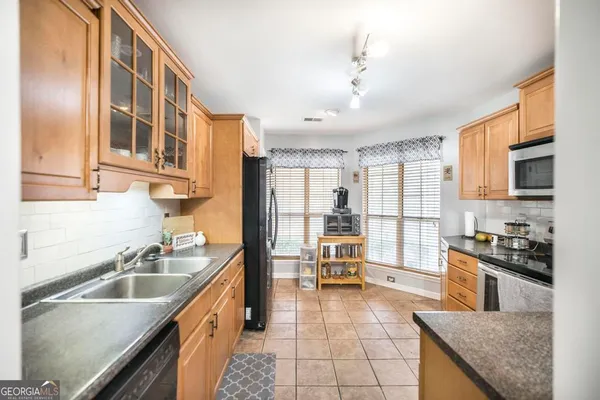 a kitchen with stainless steel appliances granite countertop a sink stove and cabinets