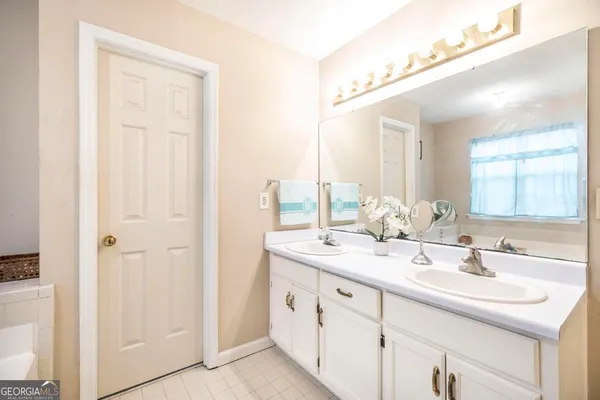 a bathroom with a double vanity sink and a mirror