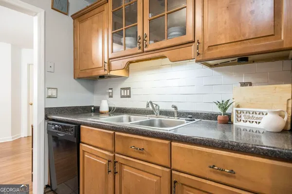 a kitchen with granite countertop stainless steel appliances a sink and cabinets