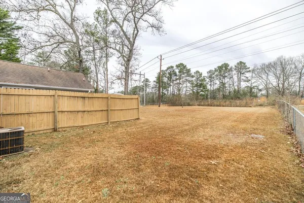 a view of backyard with wooden fence